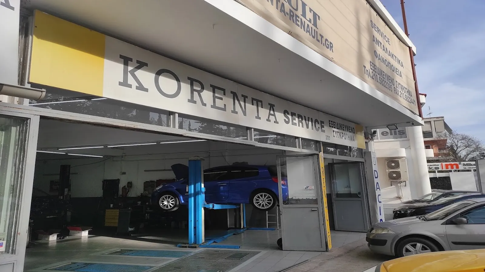 Η είσοδος του Korenta Service με την επιγραφή και ένα αυτοκίνητο στην ανυψωτική πλατφόρμα.